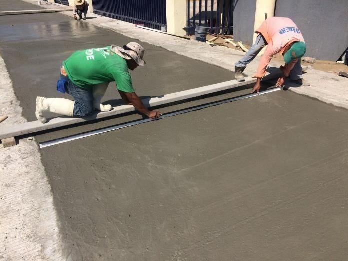 Cuadrilla de WESJE regleando concreto hidráulico en una calle